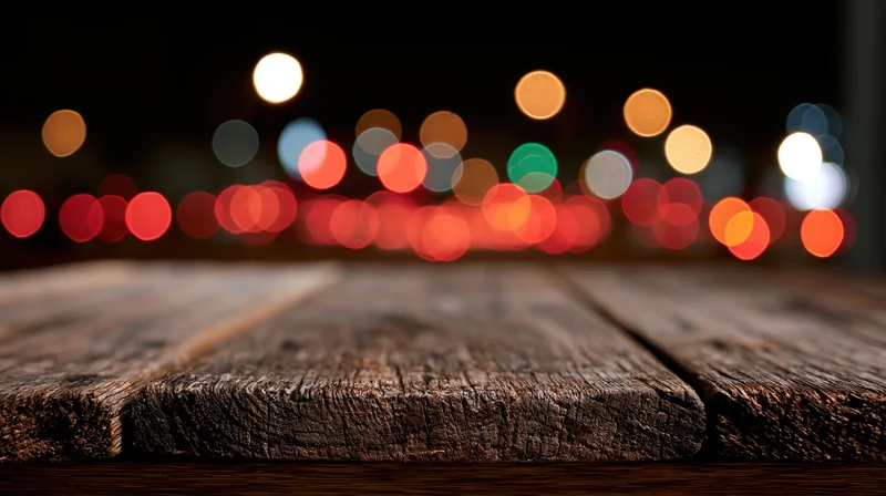 Weathered wooden table surface in foreground with blurred city lights at night