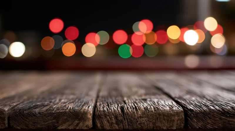 Weathered wooden table surface in foreground with blurred city lights at night