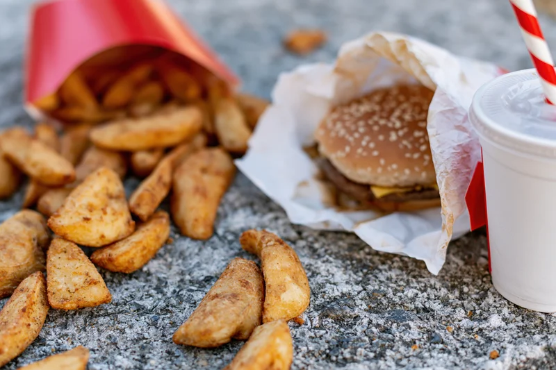 Fast food meal scattered on rough concrete ground