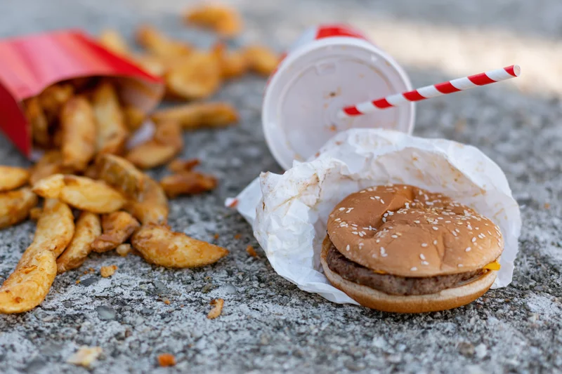 Fast food meal scattered on rough concrete ground