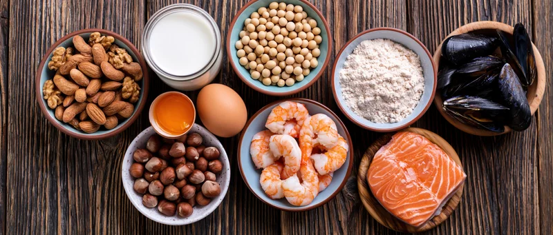 Flat lay of common food allergens arranged on dark wooden table