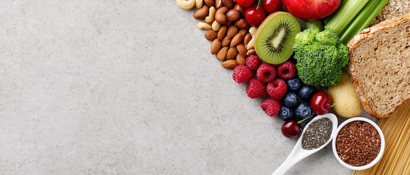 Healthy food spread arranged along right edge of gray surface with copyspace on left