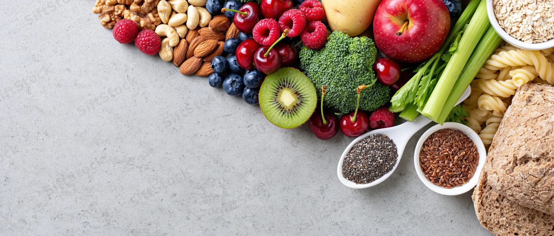 Healthy food spread arranged along right edge of light gray surface