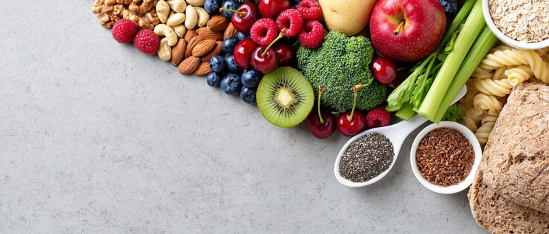 Healthy food spread arranged along right edge of light gray surface