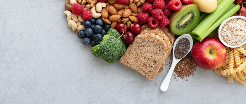 Healthy food spread arranged along the right edge of a light gray surface