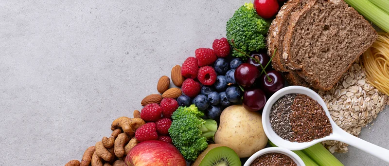 Healthy food spread arranged along right edge of light gray surface with copyspace on left