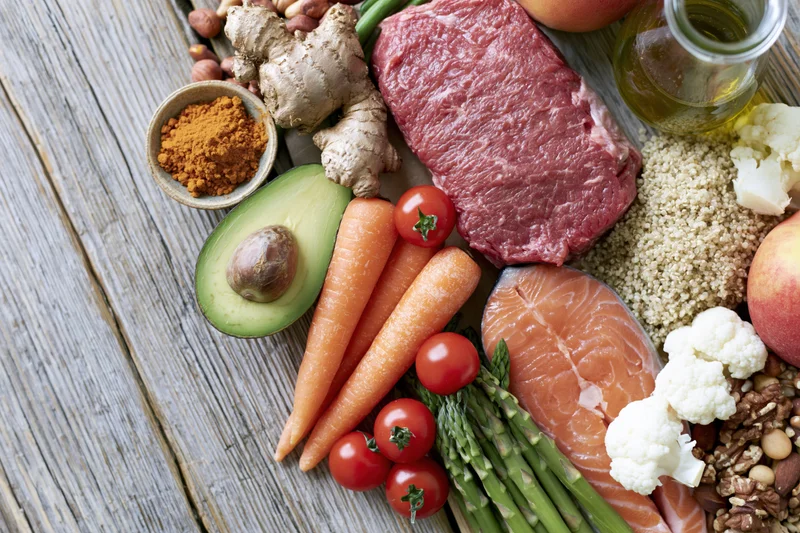 Variety of whole foods arranged on a weathered wooden surface