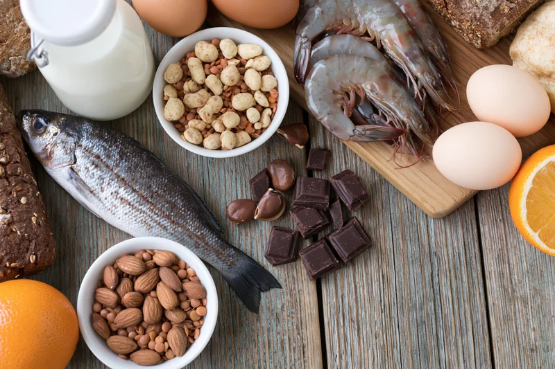 Various common food allergens arranged on a weathered wooden surface in a flat lay composition