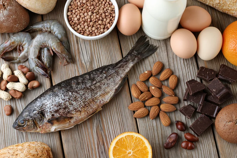 Various common food allergens arranged on a weathered wooden surface in a flat lay composition