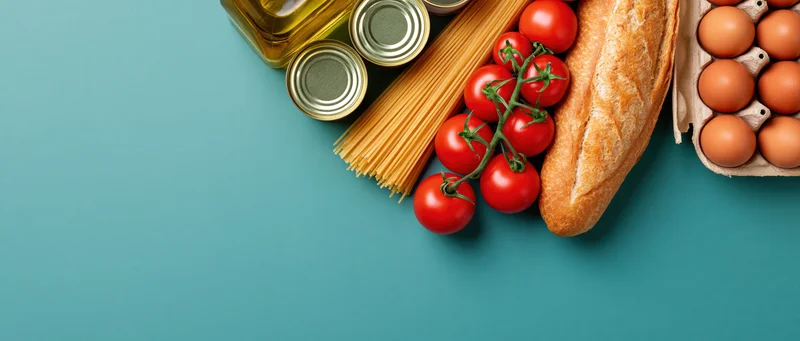 Grocery staples arranged along the right edge of a teal surface with copyspace on the left