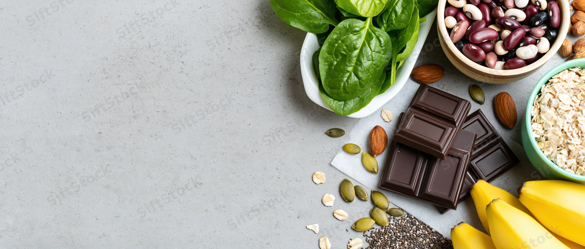 Magnesium-rich foods arranged on gray countertop in flat lay with copyspace on left