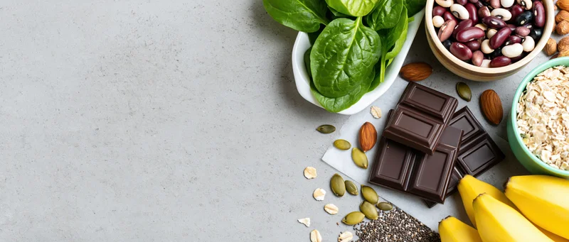 Magnesium-rich foods arranged on gray countertop in flat lay with copyspace on left