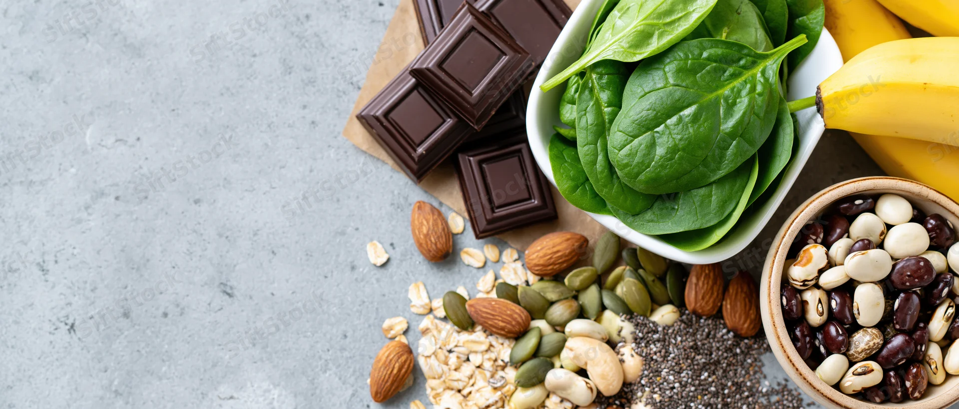 Magnesium-rich foods arranged on gray surface with copyspace on left