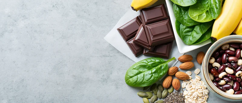 Magnesium-rich foods arranged on gray countertop in flat lay with copyspace on left