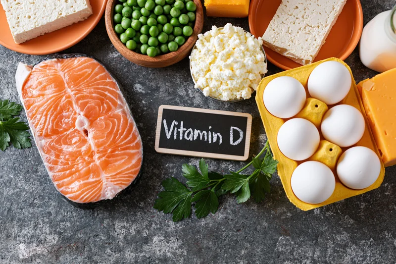 Vitamin d rich foods arranged on dark grey surface in flat lay composition