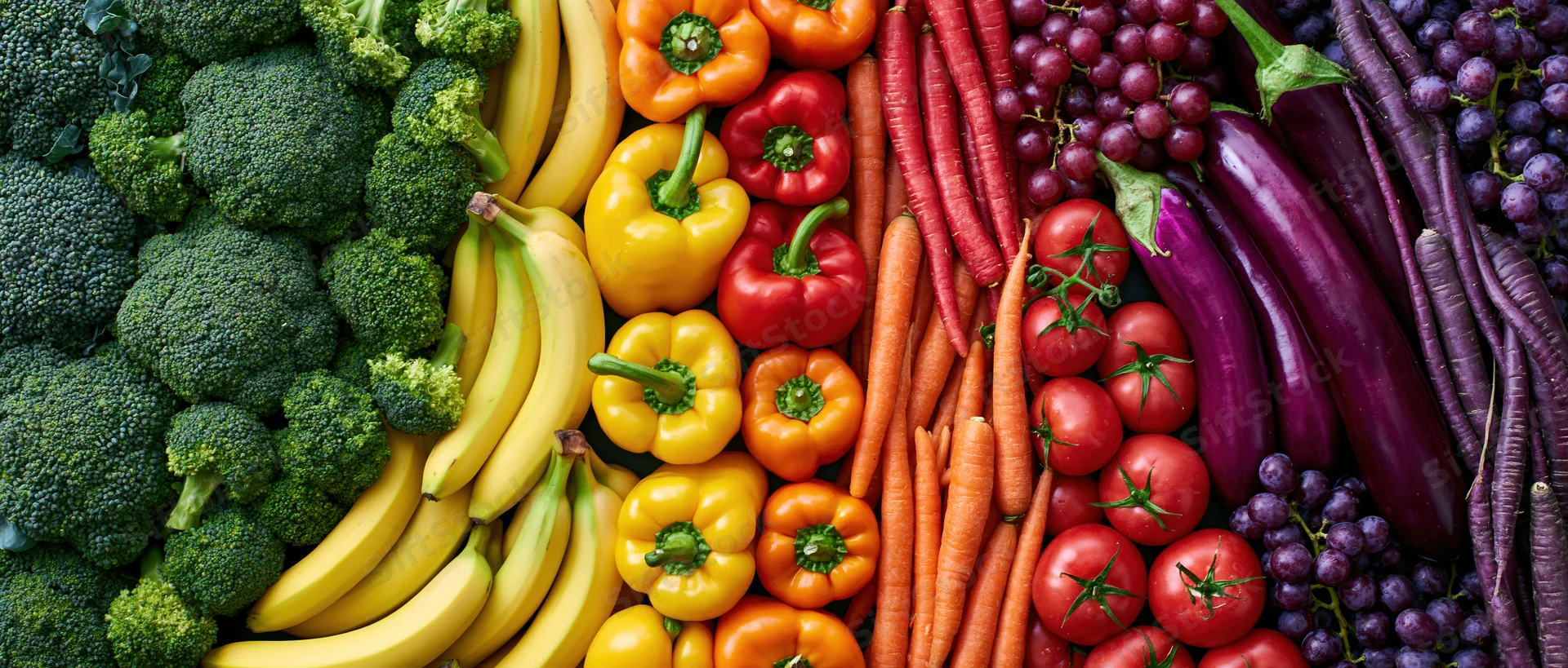 Overhead flat lay of fresh fruits and vegetables arranged in colorful rows