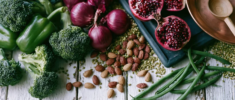 Fresh vegetables fruits and nuts arranged in flat lay on wooden surface