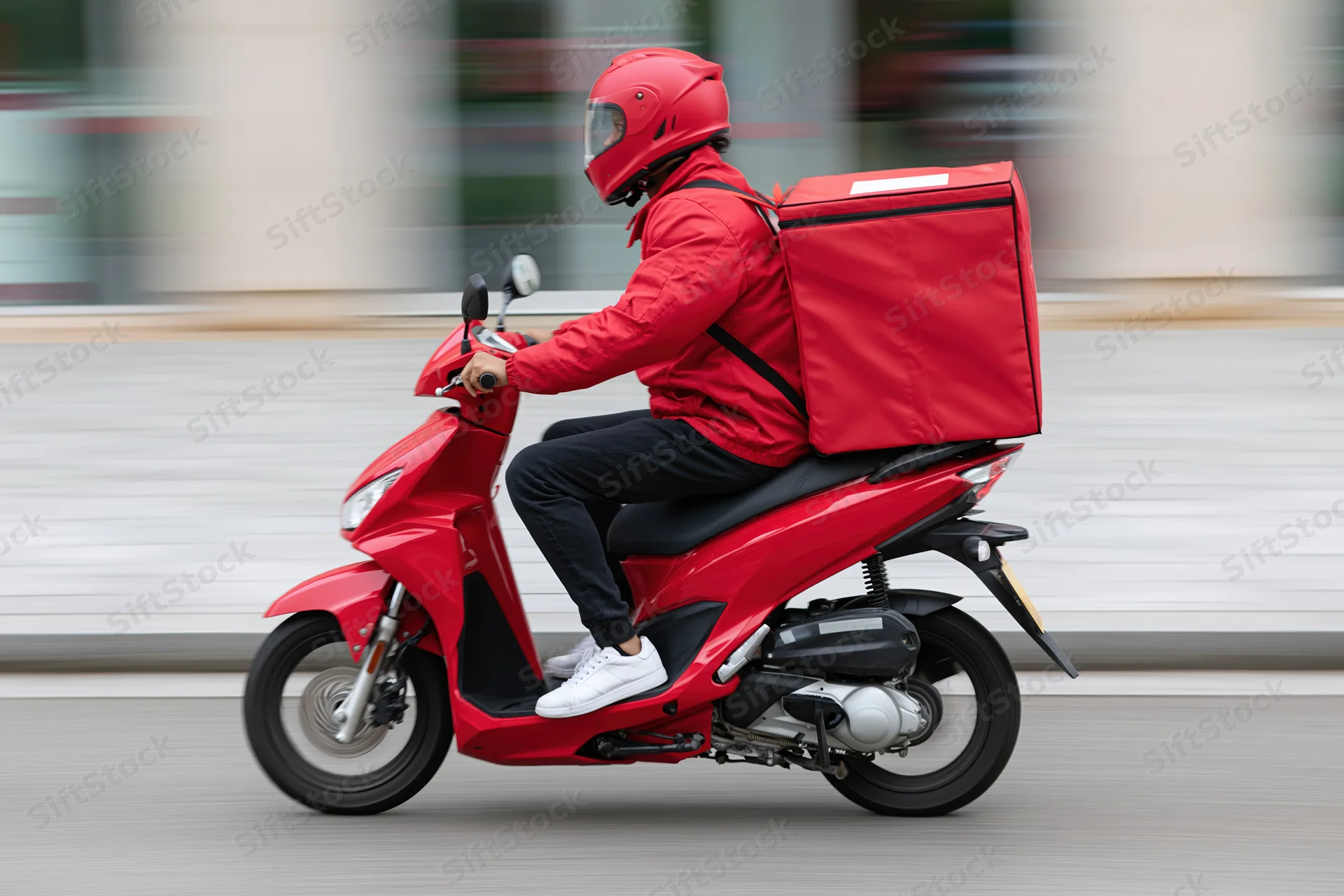 Delivery rider on red scooter moving through urban street