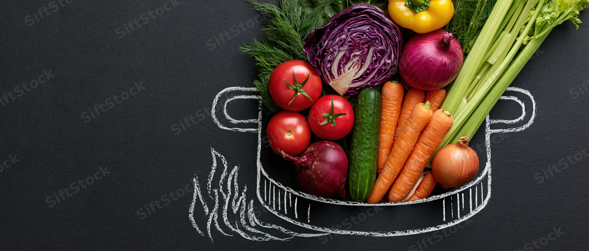 Fresh vegetables arranged in a chalk-drawn pot on a black surface with copyspace on the left