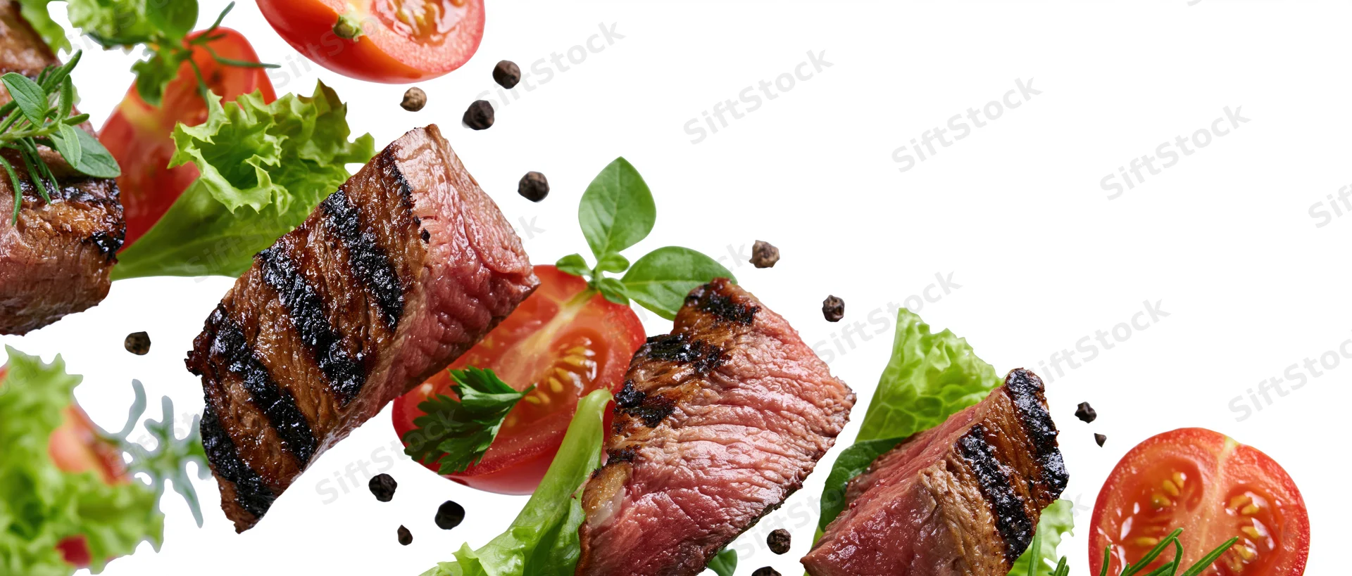 Grilled beef steak slices and fresh vegetables suspended midair against white background