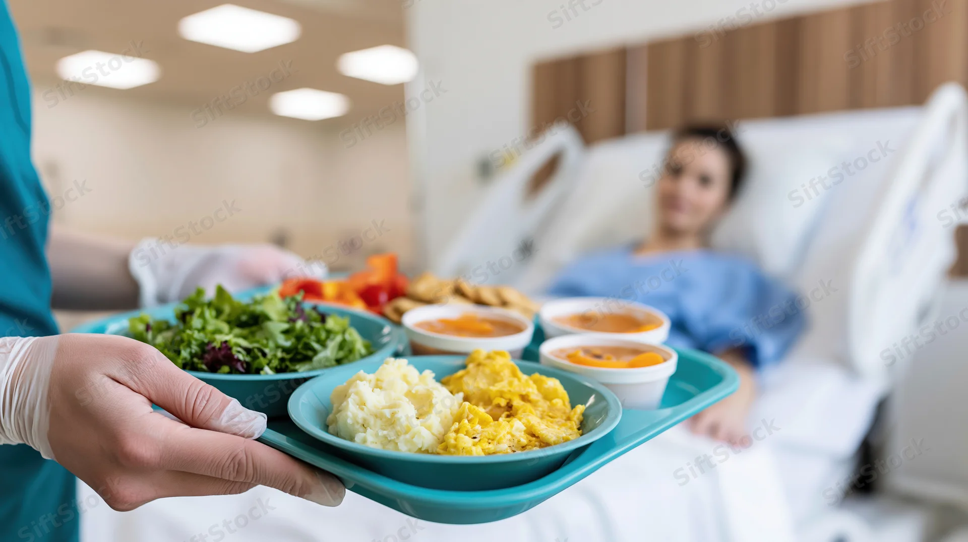 Nurse holding a tray of hospital food in front of a patient in bed