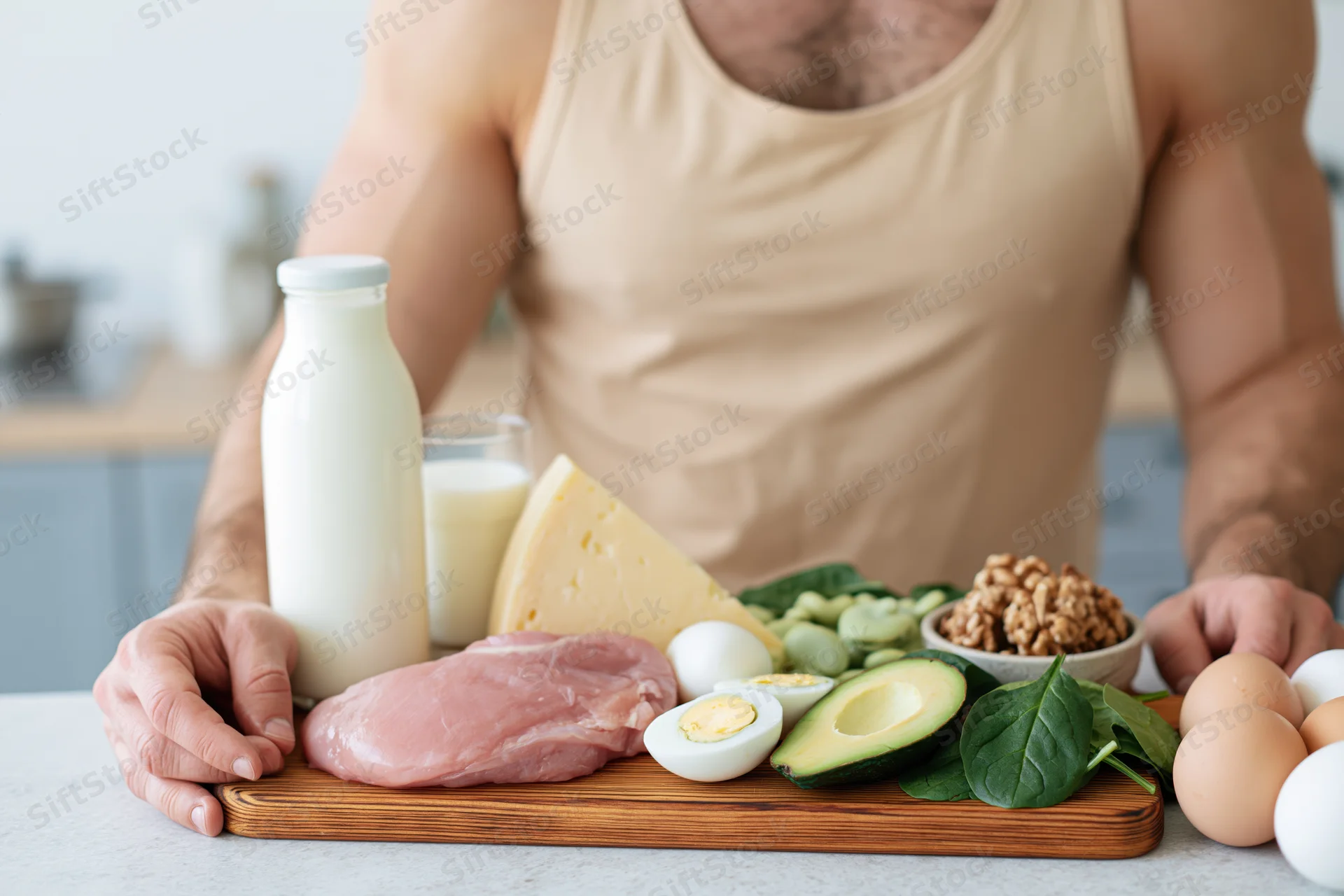 Man arranging high-protein foods on a cutting board in a kitchen