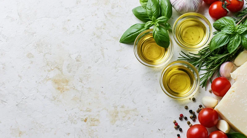 Mediterranean cooking ingredients arranged along the right edge of a white marble countertop