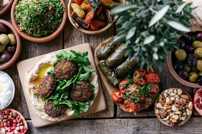 Middle eastern mezze spread with hummus, falafel, tabbouleh and olives on rustic wooden table