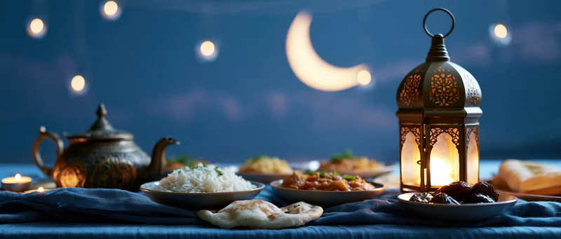 Iftar dinner spread with traditional arabic food and lantern under a crescent moon at night