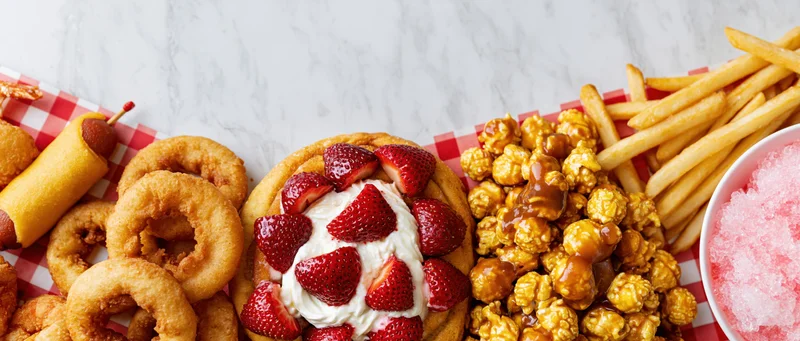 Classic american fair food arranged in a border on a marble table with checkered paper