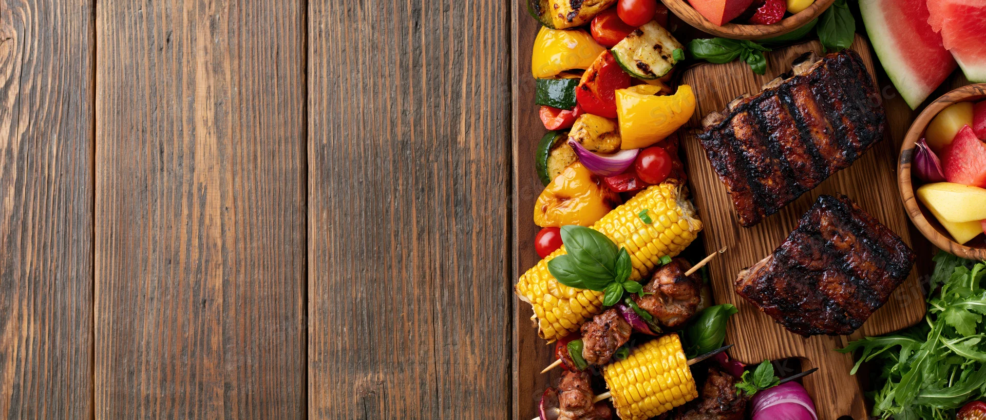 Summer barbecue spread with grilled meat and vegetables on wooden table