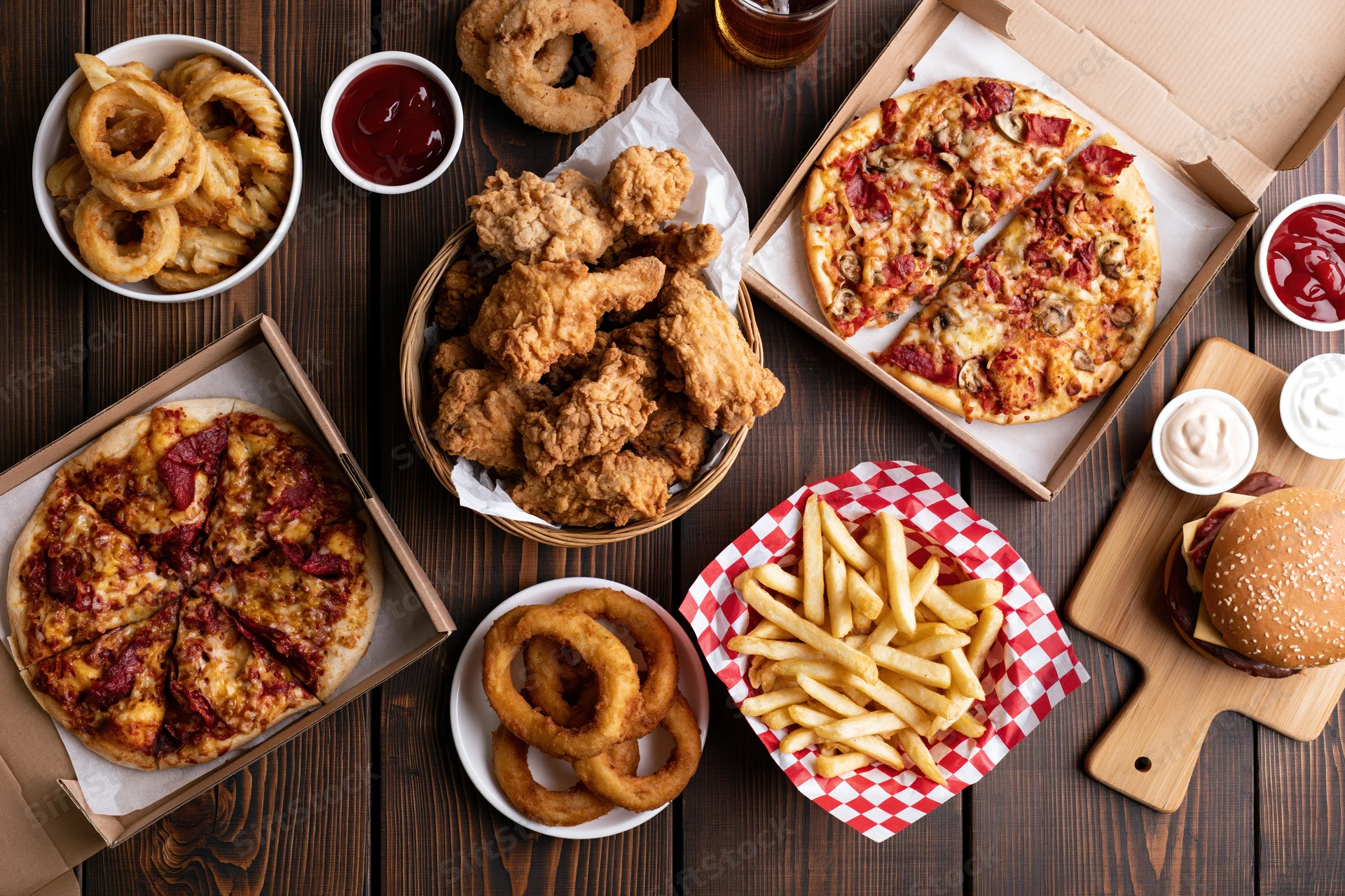 Assorted american fast food items arranged on wooden table in overhead flat lay view
