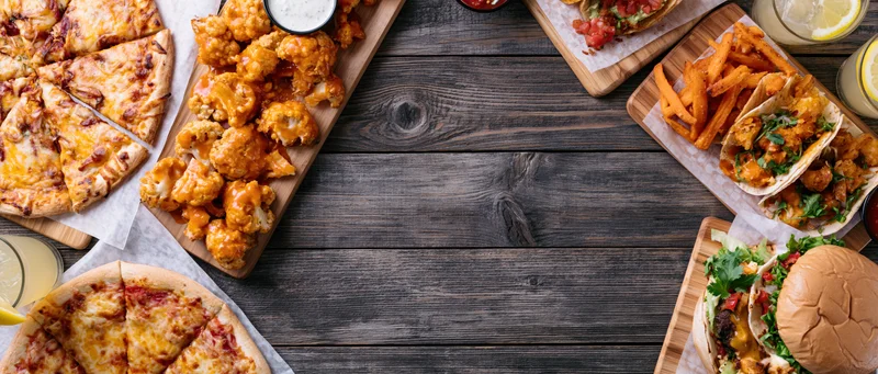 Overhead flat lay of assorted restaurant food on boards