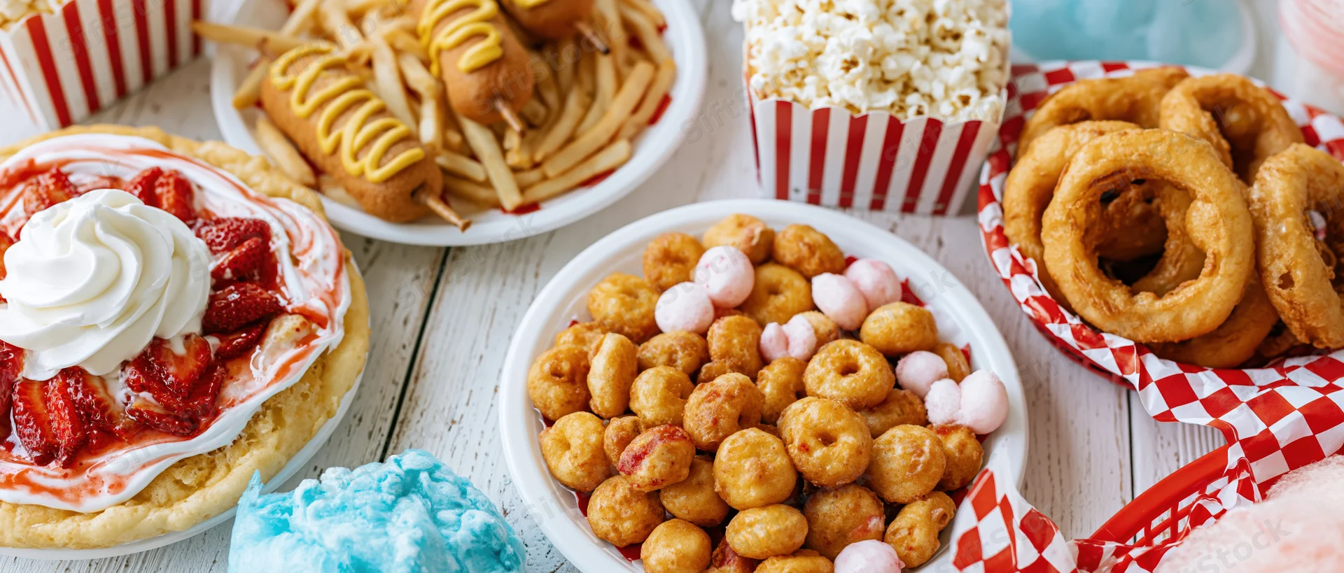 Classic american state fair foods arranged in overhead flat lay on wooden table
