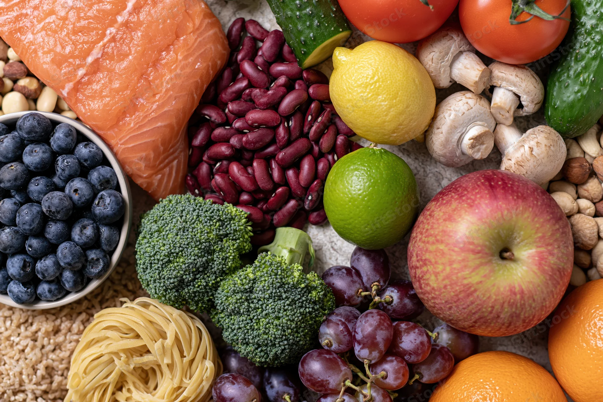 Overhead flat lay of fresh whole foods densely arranged on a surface