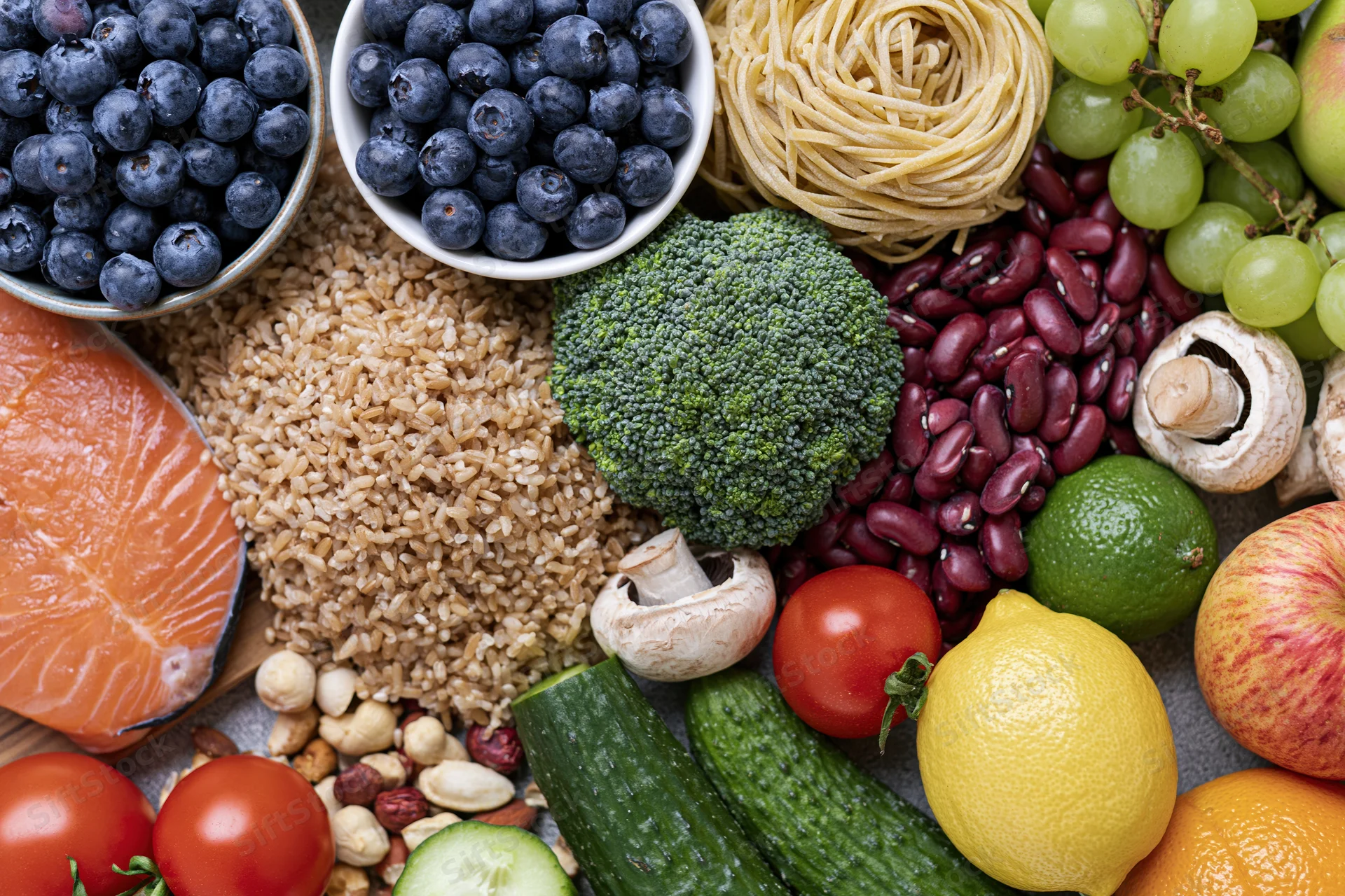 Overhead flat lay of fresh whole foods densely arranged on a surface
