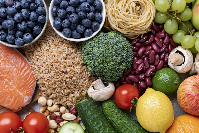Overhead flat lay of fresh whole foods densely arranged on a surface