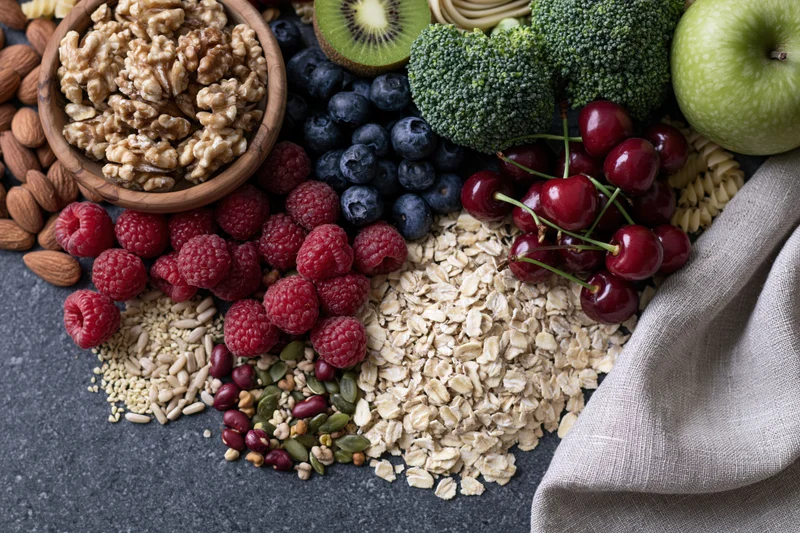 Mixed healthy foods arranged in flat lay on dark surface with linen cloth