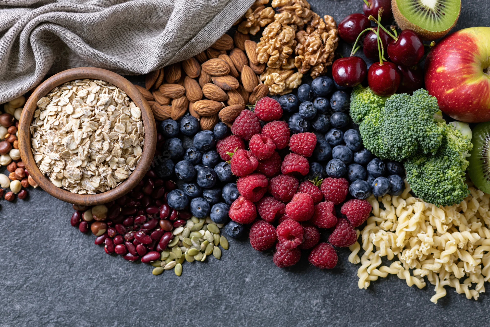 Overhead flat lay of mixed healthy foods arranged on dark surface