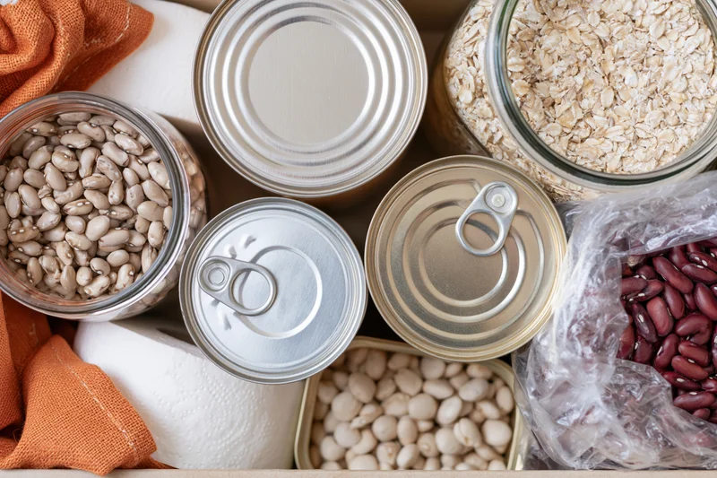 Overhead flat lay of pantry staples and household supplies arranged in a box