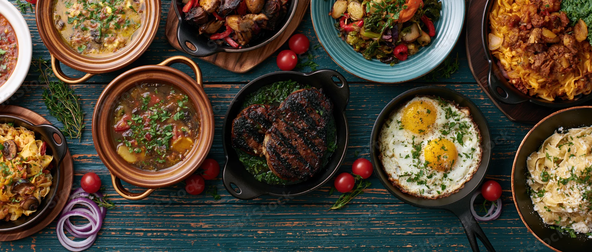 Overhead flat lay of various restaurant dishes arranged on a dark wooden table