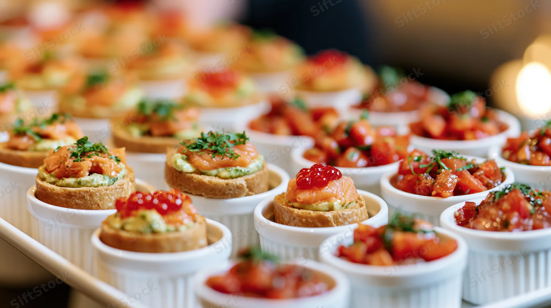 Rows of canapes and small white ramekins filled with colorful appetizers on a serving tray