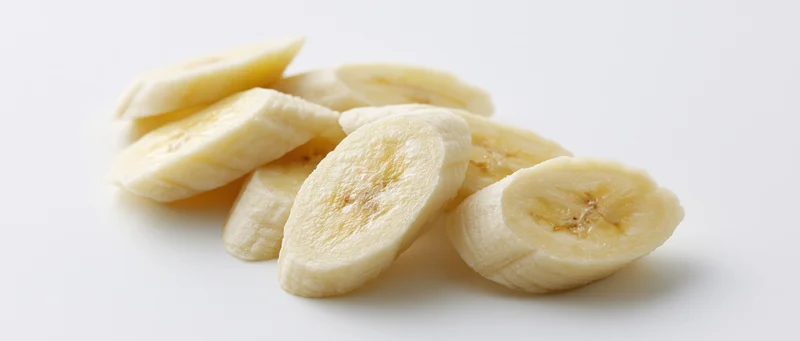 Banana slices arranged on a white surface