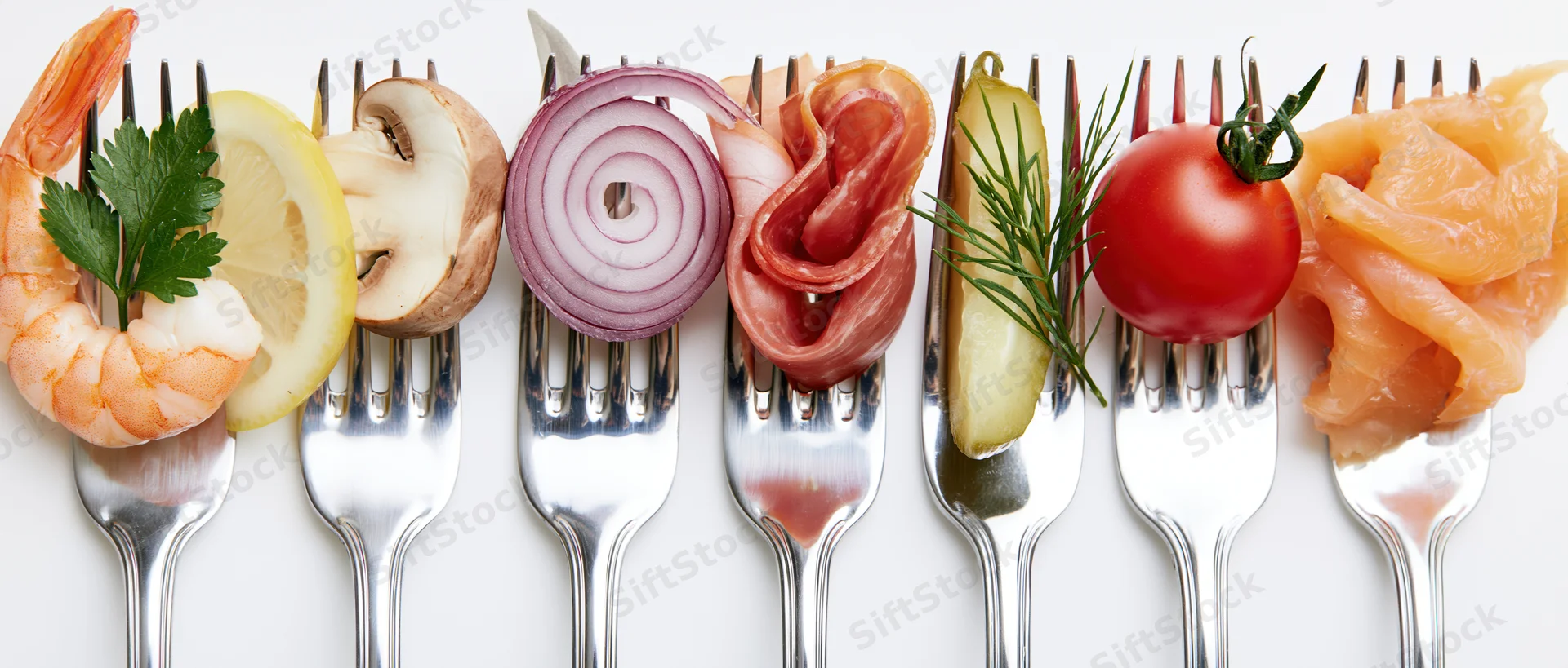 Seven forks each holding a different food item arranged in a row on a white surface