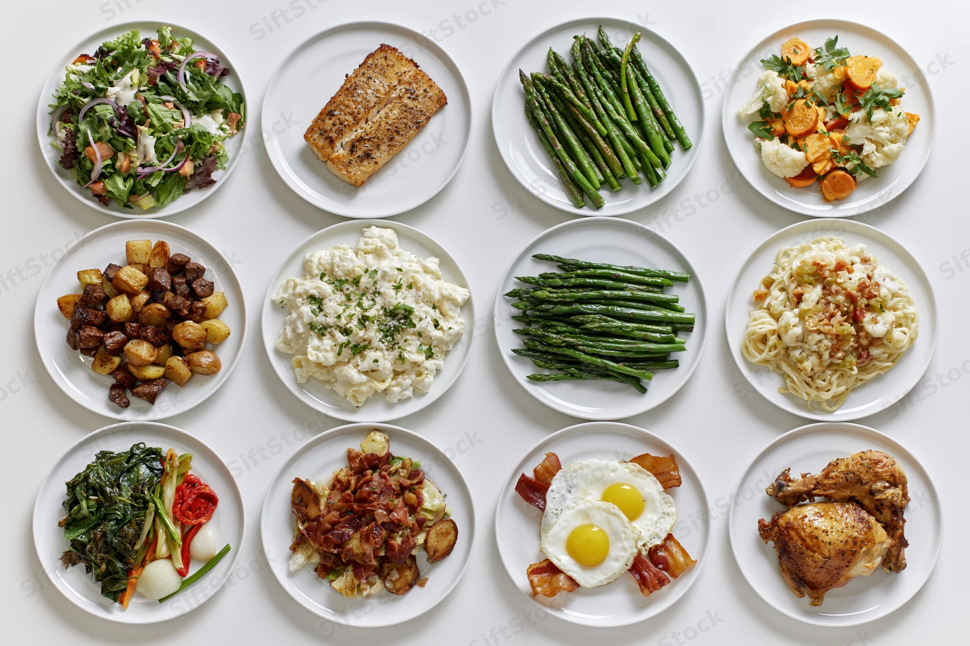 Twelve round plates arranged in grid each holding a different prepared dish on white surface