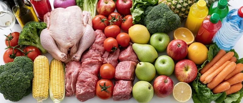 Mixed groceries arranged in a flat lay on a white surface