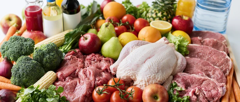 Mixed groceries arranged in a flat lay on a white surface