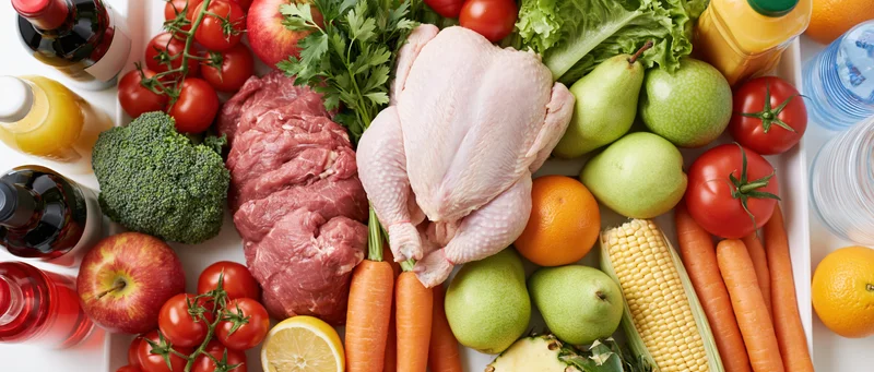 Mixed groceries arranged in a flat lay on a white surface
