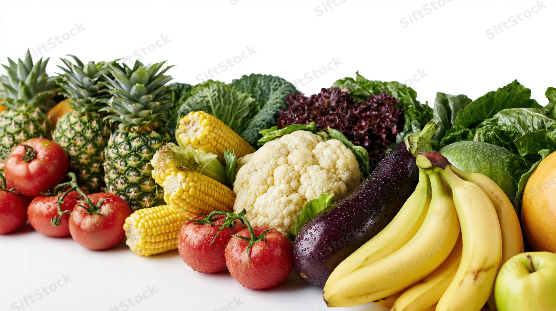 Row of fresh fruits and vegetables arranged horizontally on white background
