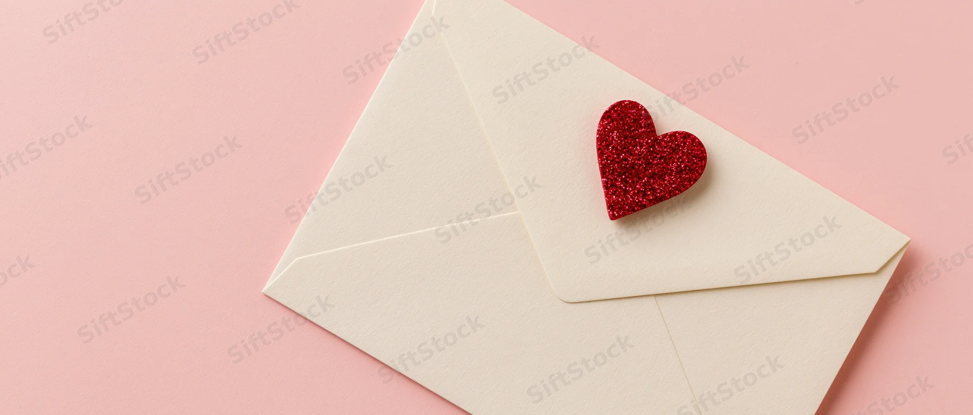Cream envelope with red glitter heart on pink background